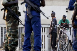 Residents look on as police and soldiers guard a voting station in Burundi's capital Bujumbura during the country's presidential elections, July 21, 2015. REUTERS/Mike Hutchings