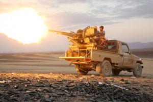 A Yemeni tribesman from the Popular Resistance Committees, supporting forces loyal to Yemen's Saudi-backed President Abedrabbo Mansour Hadi, fires a machine gun in the area of Sirwa, west of the city of Marib, some 170 kilometres (105 miles) east of the capital Sanaa on December 14, 2015. AFP PHOTO / ABDULLAH AL-QADRY / AFP / ABDULLAH AL-QADRY