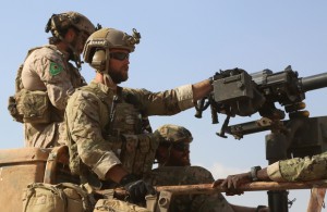 Armed men in uniform identified by Syrian Democratic forces as US special operations forces ride in the back of a pickup truck in the village of Fatisah in the northern Syrian province of Raqa on May 25, 2016.  US-backed Syrian fighters and Iraqi forces pressed twin assaults against the Islamic State group, in two of the most important ground offensives yet against the jihadists. The Syrian Democratic Forces (SDF), formed in October 2015, announced on May 24 its push for IS territory north of Raqa city, which is around 90 kilometres (55 miles) south of the Syrian-Turkish border and home to an estimated 300,000 people. The SDF is dominated by the Kurdish People's Protection Units (YPG) -- largely considered the most effective independent anti-IS force on the ground in Syria -- but it also includes Arab Muslim and Christian fighters.  / AFP / DELIL SOULEIMAN        (Photo credit should read DELIL SOULEIMAN/AFP/Getty Images)