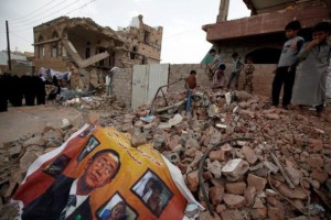 A defaced poster of the U.N. Secretary-General Ban Ki-moon is seen on the rubble of a house during a vigil marking one year since a Saudi-led air strike on a residential area in Sanaa, Yemen June 21, 2016. REUTERS/Khaled Abdullah