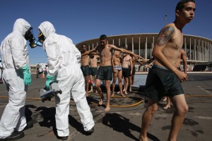 A soldier dressed in a hazmat suit holds a machine that reads radiation levels, during the practice of a decontamination plan against a chemical attack, outside the National Stadium, which will host the 2016 Summer Olympics soccer matches in Brasilia, Brazil, Thursday, July 28, 2016. Brazil isnt a newcomer to hosting mega-events. Every year it welcomes millions of foreign visitors during the weeklong Carnival celebration. But it has almost no experience fighting terrorism. The country has long prided itself on having an enemy-free foreign policy, one that rejects military intervention. (AP Photo/Eraldo Peres)