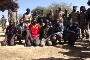 Former members of insurgent group Boko Haram gather in front of Chadian soldiers in Ngouboua, Chad, April 22, 2015. The young men said they were Chadian nationals forced to join Boko Haram while studying the Quran in Nigeria, and that they escaped and turned themselves in to Chadian authorities. Picture taken April 22, 2015. REUTERS/Moumine Ngarmbassa - RTX1A95S